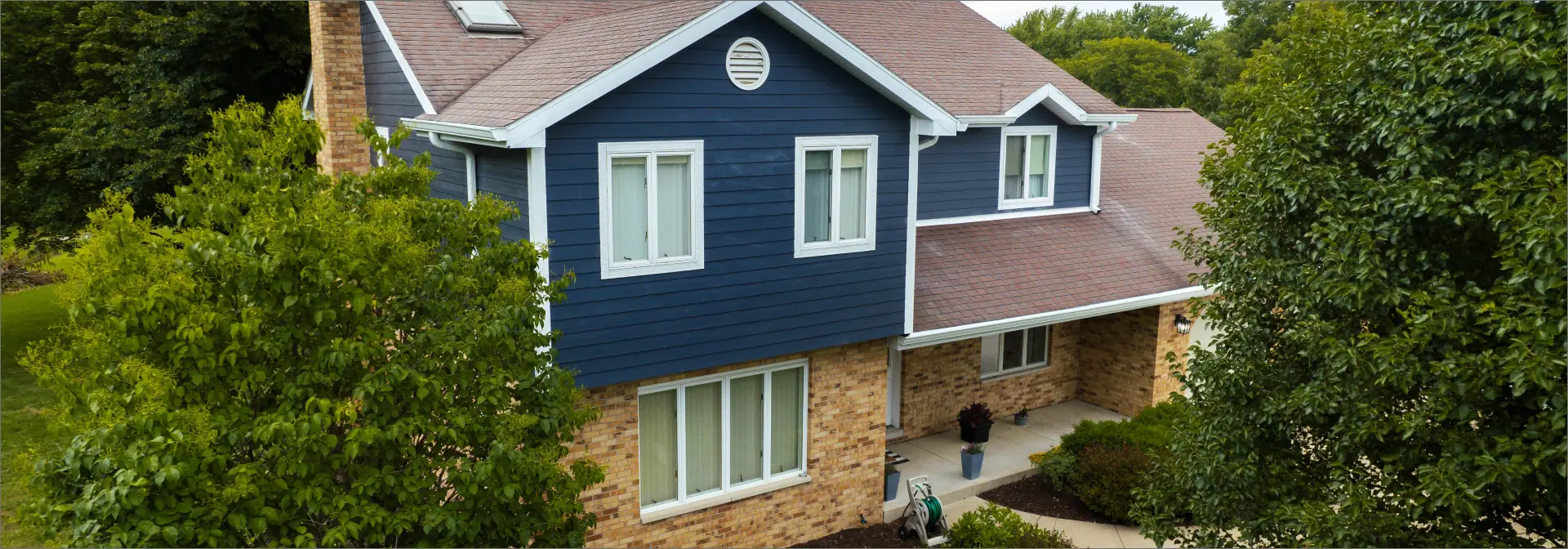 home with Blue Clapboard Siding and Brick Veneer. Courtesy of 3JM Exteriors
