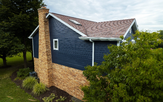 Sideview of home with Blue Clapboard Siding and Brick Veneer.